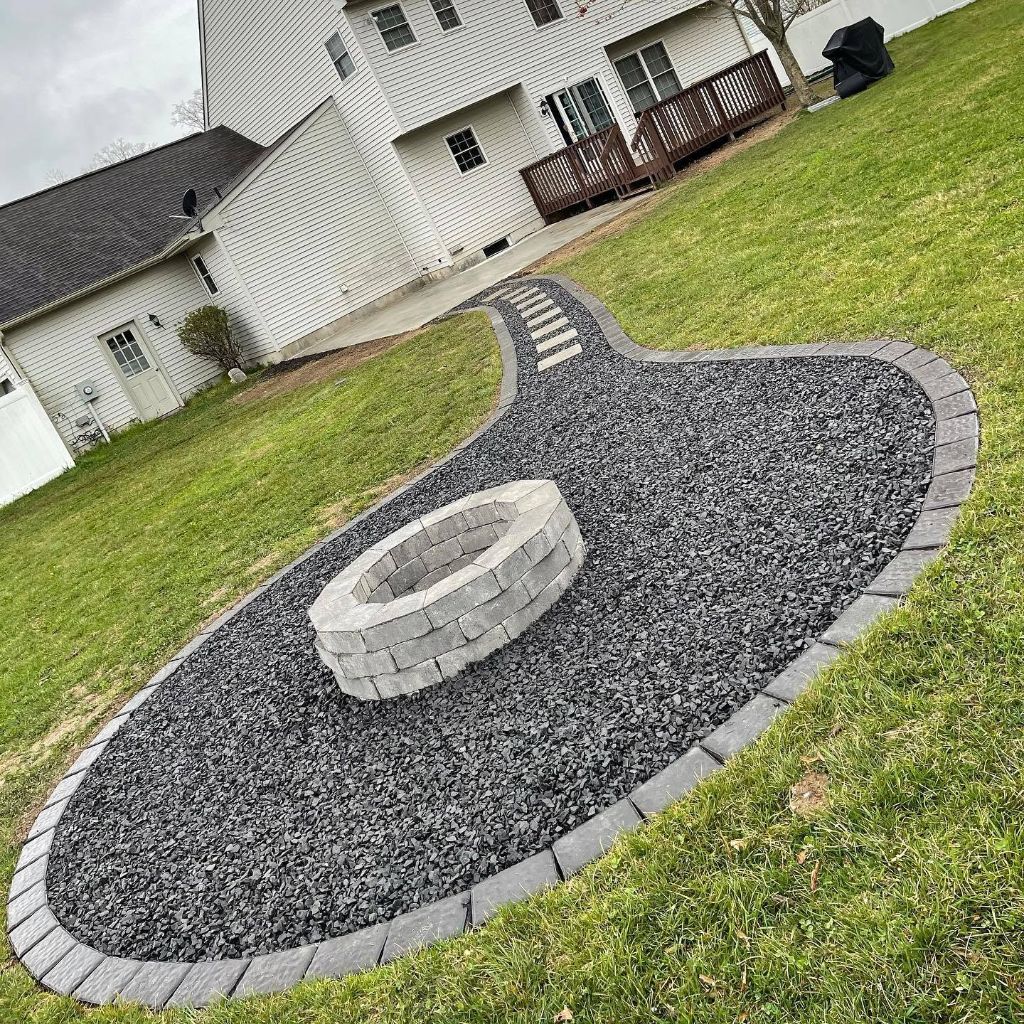 Stone fire pit surrounded by gravel hardscaping area South Jersey