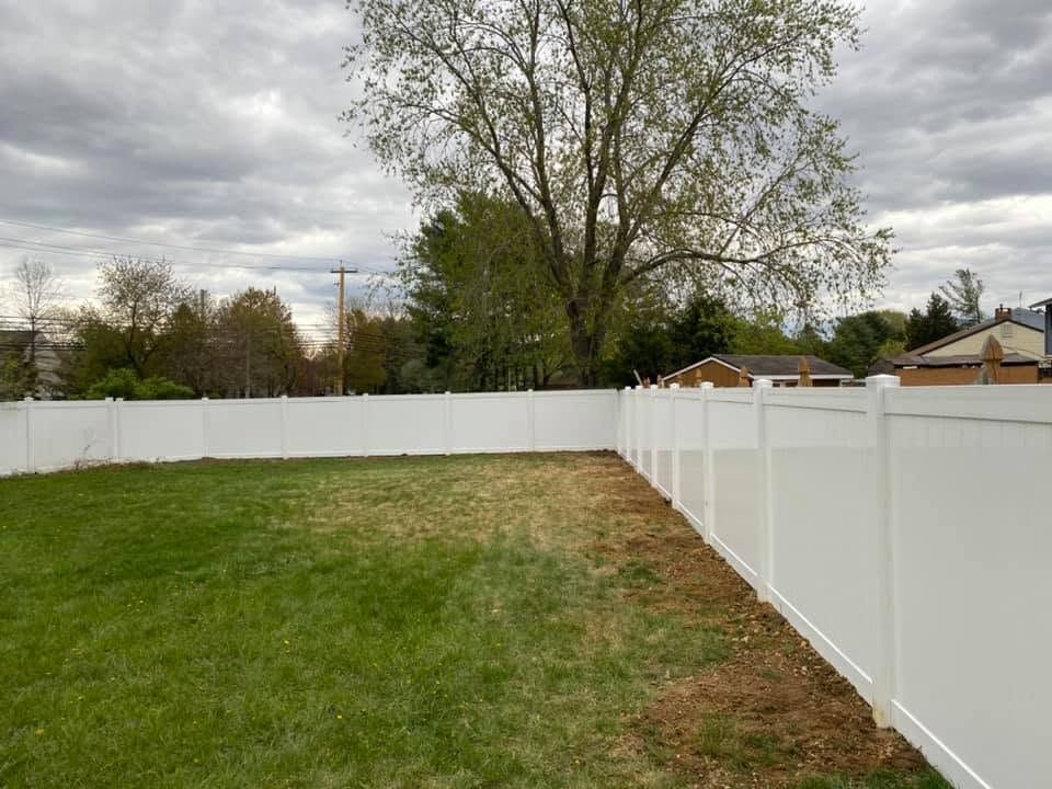 Clean green lawn along white vinyl privacy fence South Jersey
