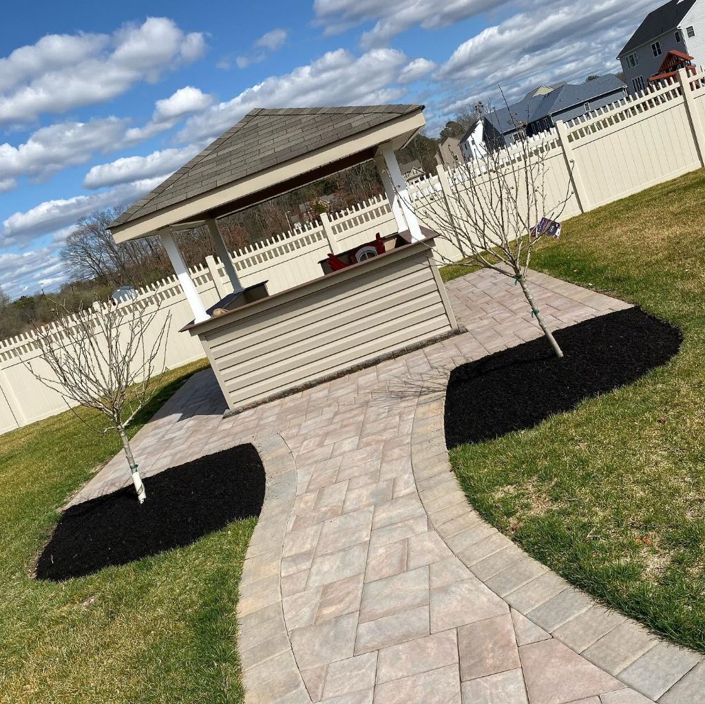 Paver patio leading to gazebo with mulch beds and trees South Jersey